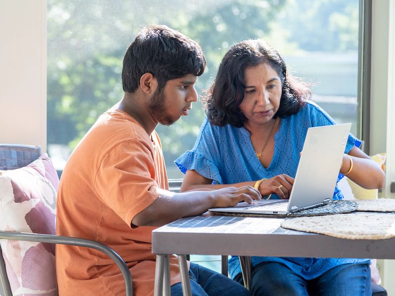 Son and mother looking at laptop 